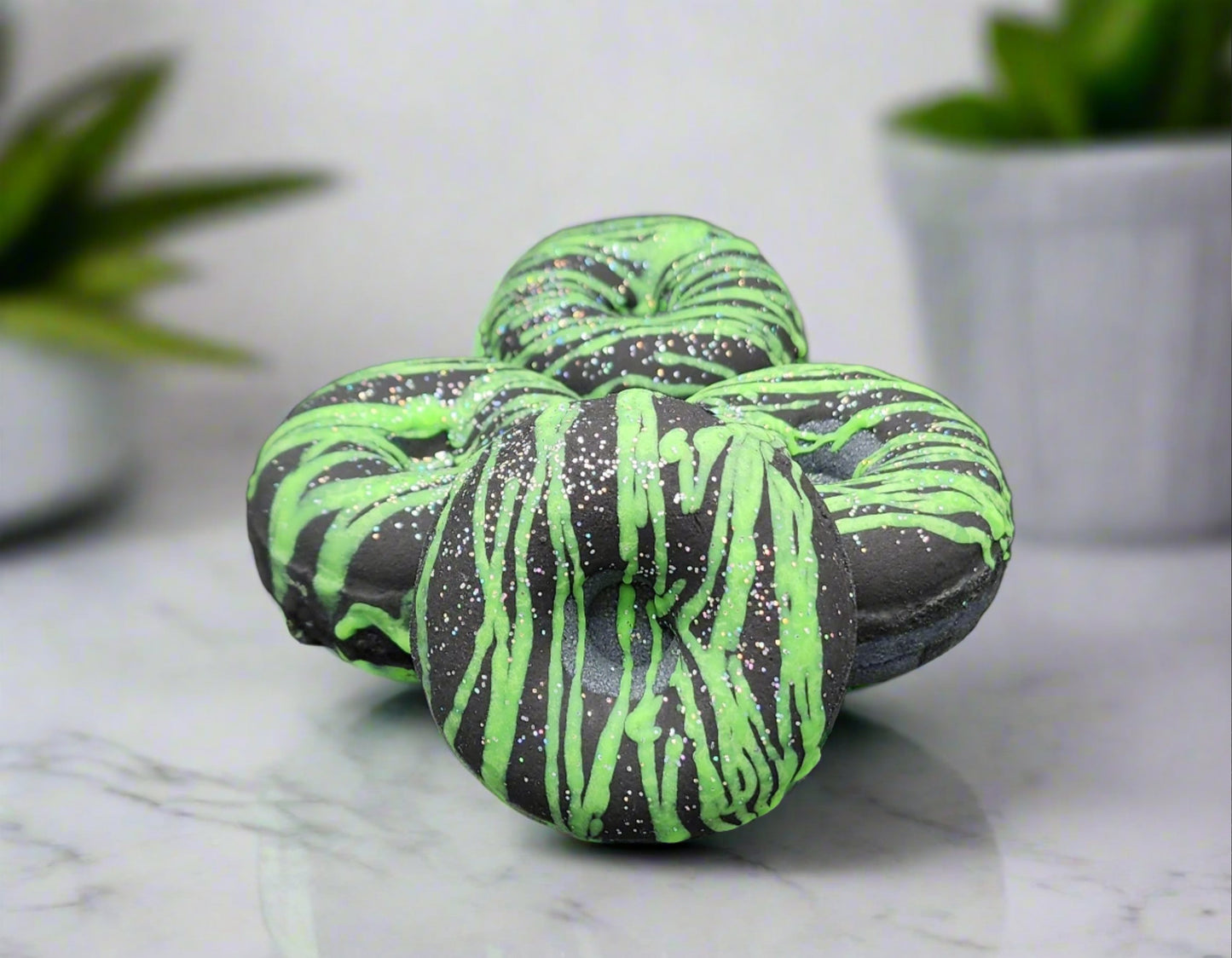 Black and neon green drizzle goth donut bath bomb with holographic eco glitter by grim temptation
