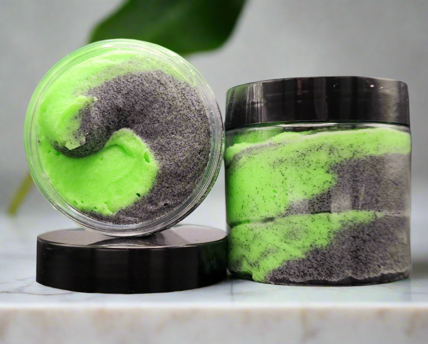 Aurora Gorealis, neon green and black swirled goth themed sugar scrub by grim temptations. Sea lily and lime scented sugar scrub sitting open on a bathroom counter.
